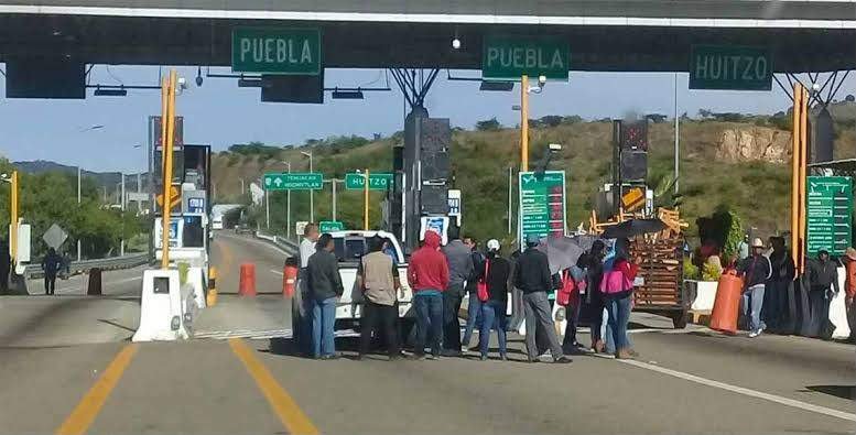 Normalistas toman la caseta de Huitzo y cobran cuota a automovilistas